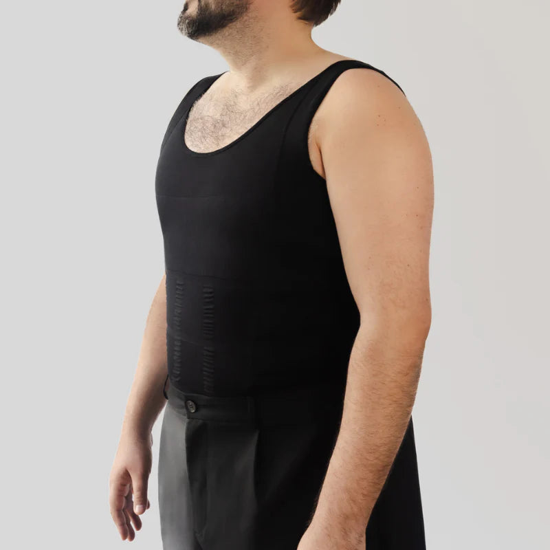 Man wearing a black tank top and dark pants against a plain background